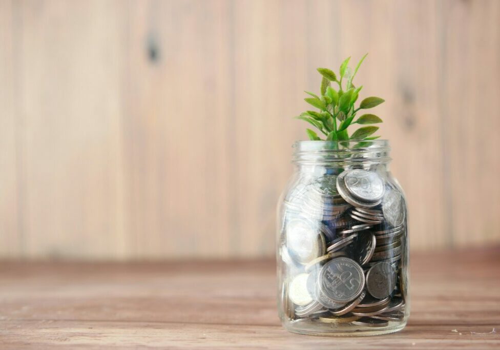 money in a jar with a plant growing - financing a custom home build blog image - Pathway Builders Idaho